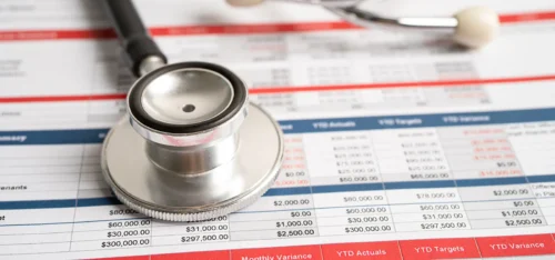 Medical bills under a stethoscope