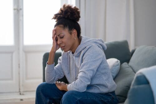 tired worried woman on a couch