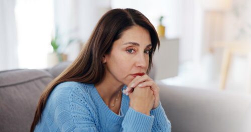 woman on couch looking into the distance