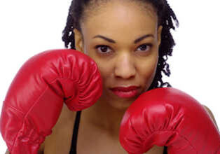 Black woman wearing boxing gloves