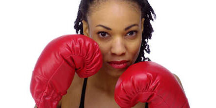 Black woman wearing boxing gloves