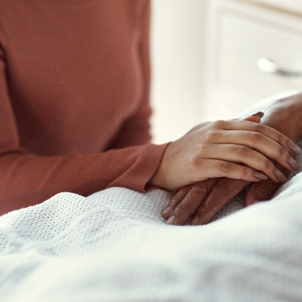 Cancer, healthcare and support with a woman holding hands with her man in the hospital. Medicine, insurance and trust with a couple in a clinic for treatment or help before death, mourning and loss