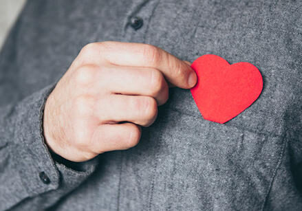 man holding heart over heart