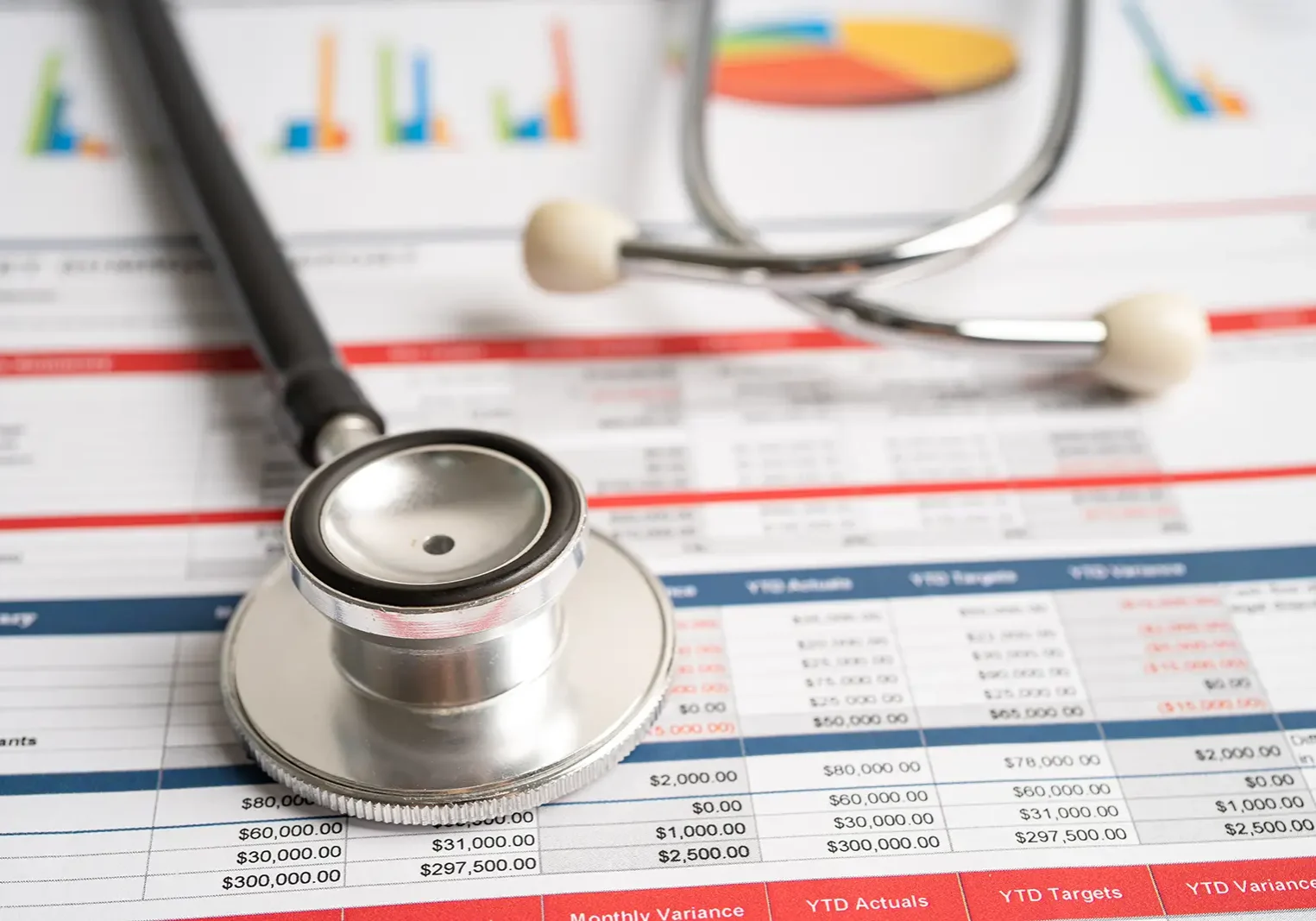 medical-bills-piling-up Medical bills with a stethoscope laying on top